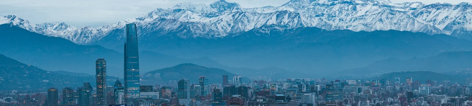 Seguro viagem Chile: Cordilheira dos Andes ao entardecer sobre Santiago